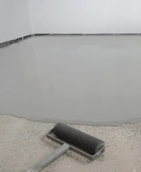 Applying self leveling concrete for smooth basement floor renovation