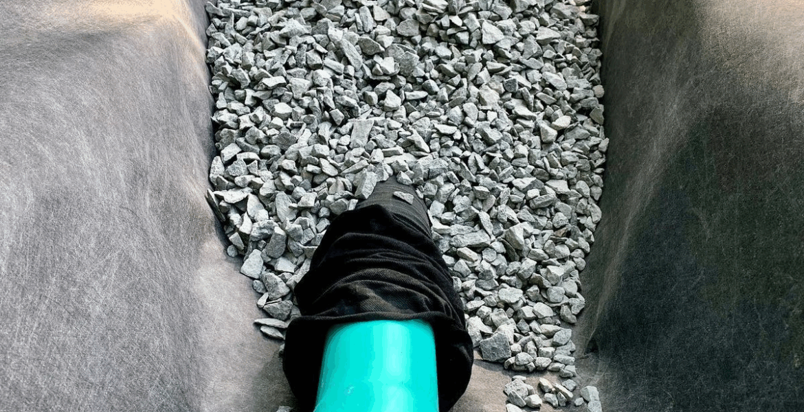 French drain installation with gravel and perforated drainage pipe